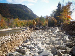 Photo of excavators placing rock for Saco Rive Embankment Reconstruction in Harts Location, NH