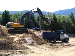 Photo of excavator loading dump truck